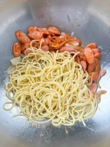Adding sausages to the pan for the Naporitan cooking process.