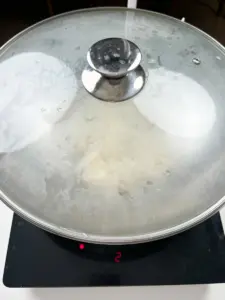 Adding water to steam the Korean radish with perilla seeds.