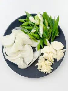 Sliced garlic minced garlic green onion and julienned onion prepped for Korean stir fry