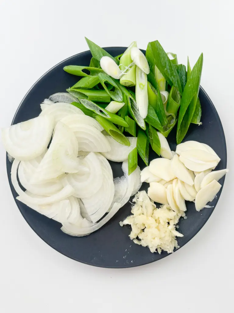 Sliced garlic minced garlic green onion and julienned onion prepped for Korean stir fry