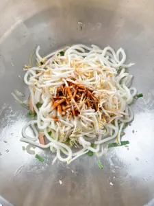 Tossing udon noodles on high heat with Korean sauce — final step of seafood udon stir fry