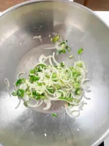 Garlic, onion, and green onion stir-frying in hot oil for Korean seafood udon stir fry