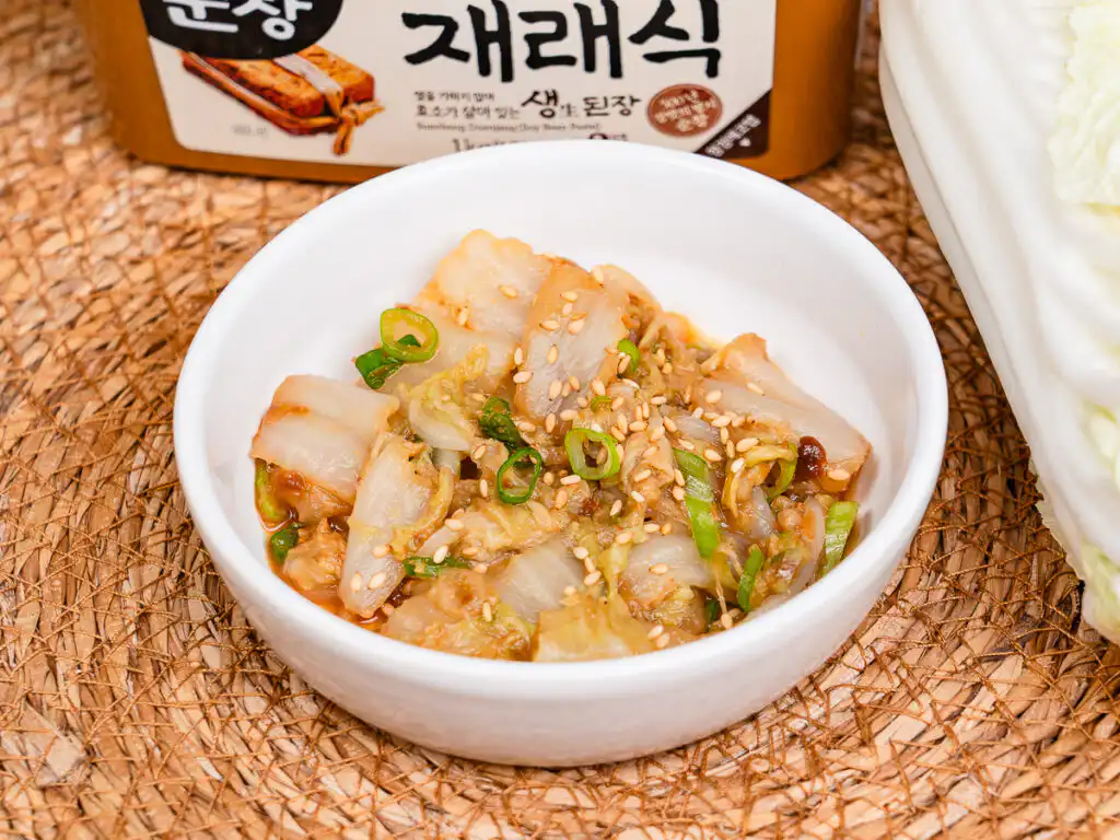 Best Korean Cabbage Side Dish Recipe – Doenjang Baechu Namul korean cabbage side dish baechu namul served in a white ceramic bowl with sesame seeds on top