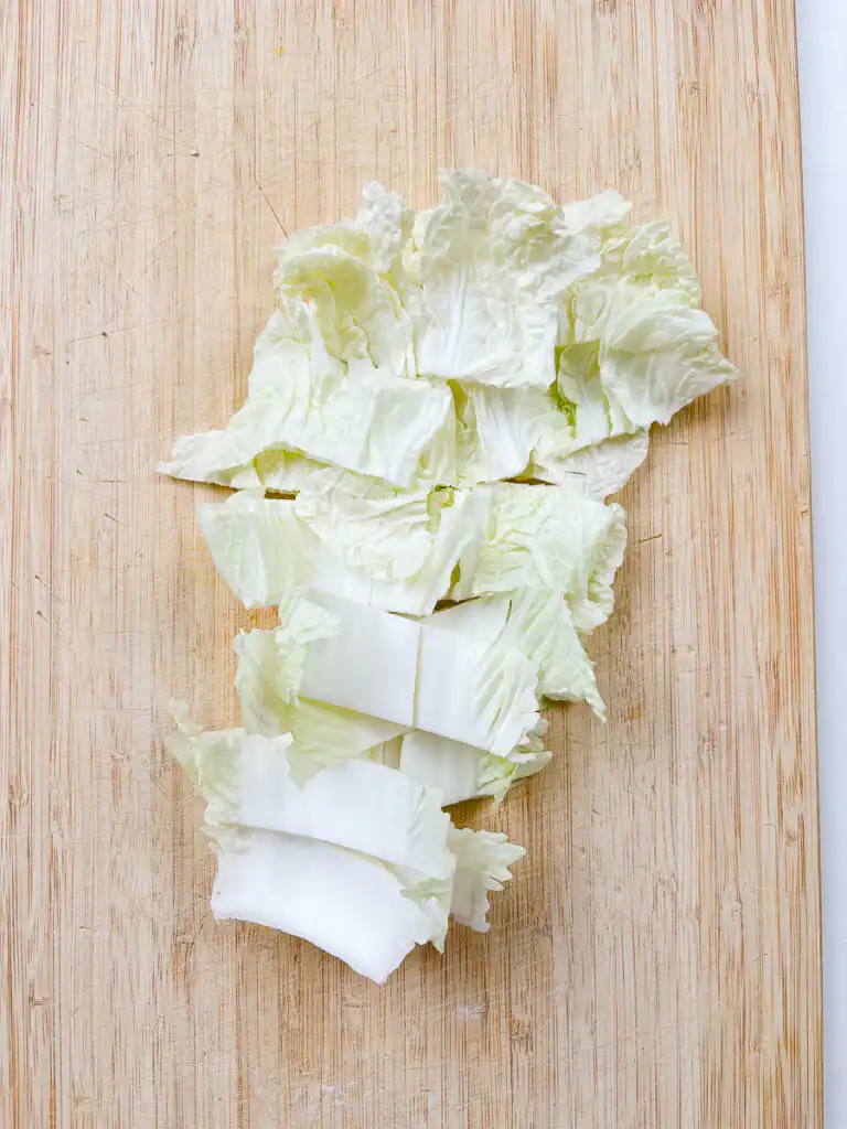 Best Korean Cabbage Side Dish Recipe – Doenjang Baechu Namul napa cabbage cut into 2cm pieces on wooden cutting board for korean cabbage side dish