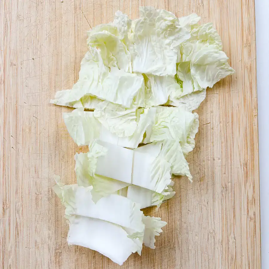 Best Korean Cabbage Side Dish Recipe – Doenjang Baechu Namul napa cabbage cut into 2cm pieces on wooden cutting board for korean cabbage side dish