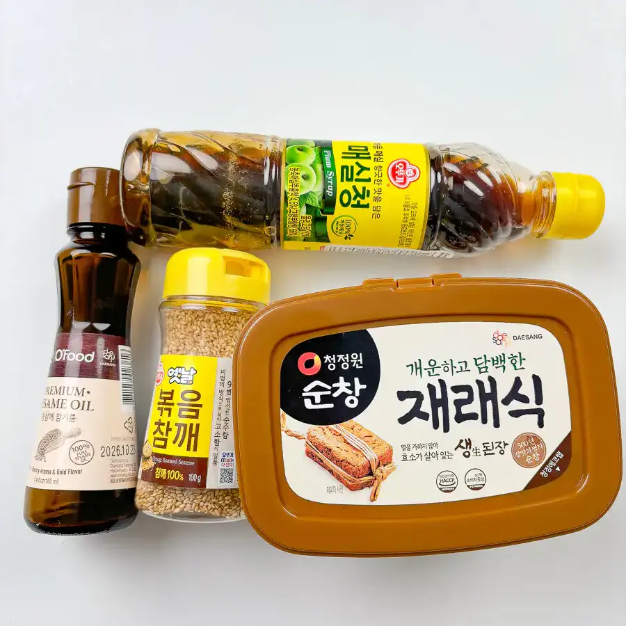 Best Korean Cabbage Side Dish Recipe – Doenjang Baechu Namul flat lay ingredients for korean cabbage side dish baechu namul including doenjang, sesame oil, plum syrup
