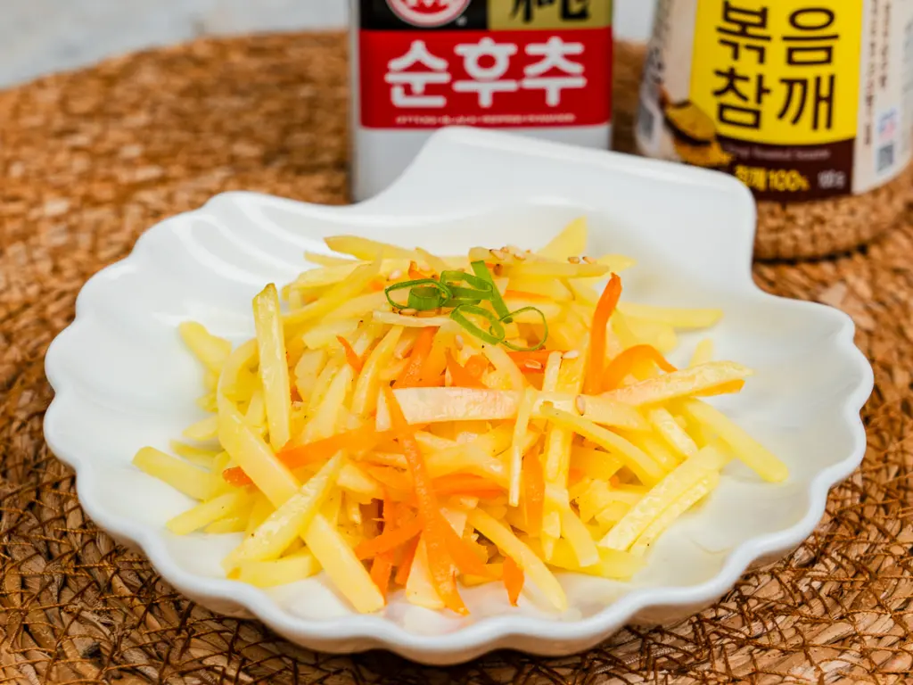 Korean potato side dish gamja bokkeum with carrots and green onion