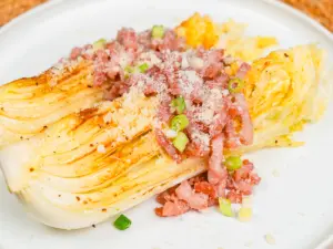 close up of cabbage steaks with cheese parmesan melting over golden caramelized napa cabbage