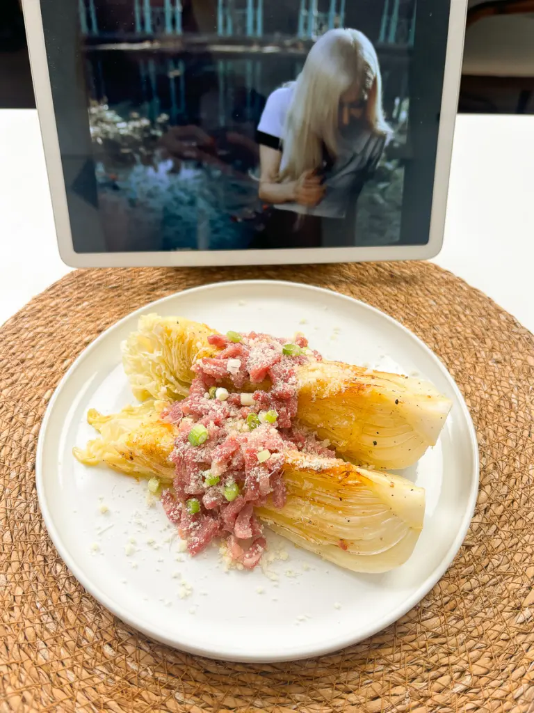 napa cabbage side dish of pan fried cabbage steaks plated alongside grilled steak and pasta