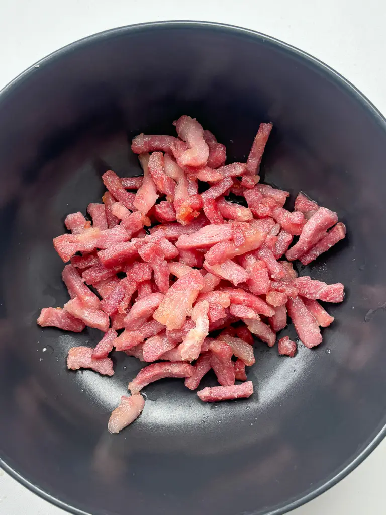 bacon rendering in pan leaving behind golden fat for napa cabbage side dish