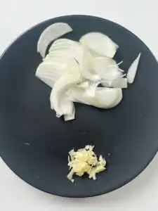 Thinly sliced onion and minced garlic prepared for eomuk bokkeum
