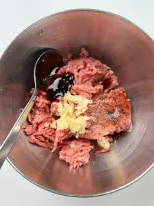 Ground beef and pork blend being seasoned with soy sauce and garlic for tteokgalbi