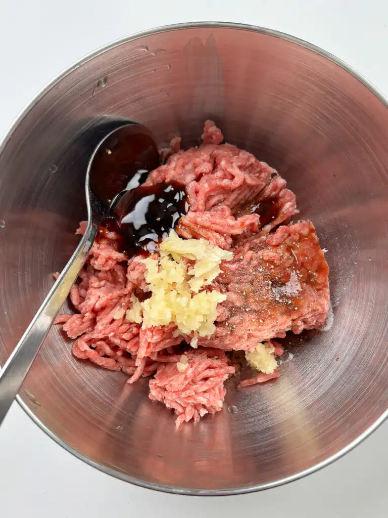 Ground beef and pork blend being seasoned with soy sauce and garlic for tteokgalbi