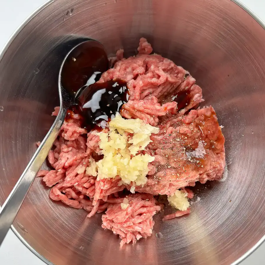 Ground beef and pork blend being seasoned with soy sauce and garlic for tteokgalbi