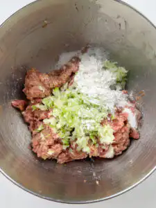 Glutinous rice flour being added to seasoned tteokgalbi meat mixture