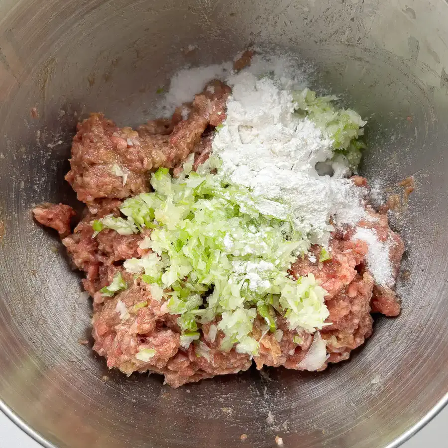 Glutinous rice flour being added to seasoned tteokgalbi meat mixture