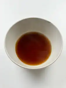 Sweet soy glaze being poured over pan-fried tteokgalbi