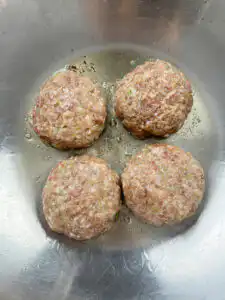 Four shaped tteokgalbi patties arranged before pan-frying