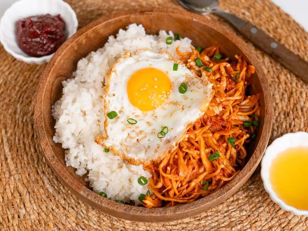 Healthy Korean rice bowl with spicy cabbage and fried egg
