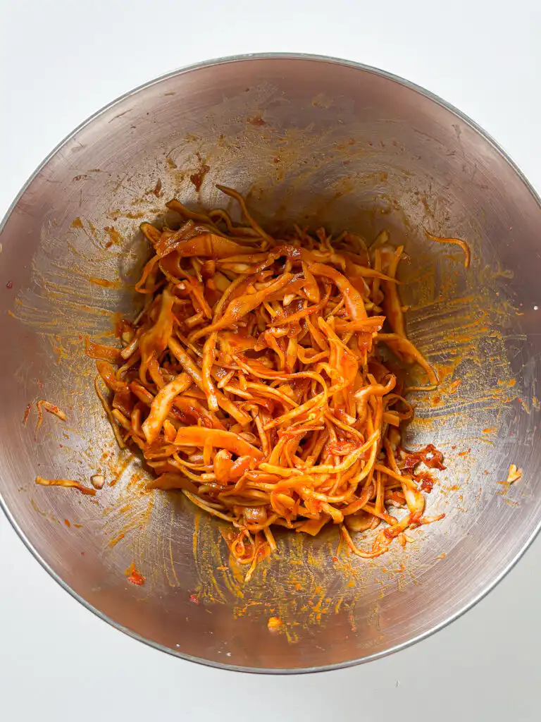 Mixing spicy gochugaru bibimbap sauce in a small bowl