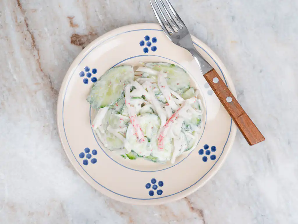 overhead view of korean cucumber salad in ceramic plate