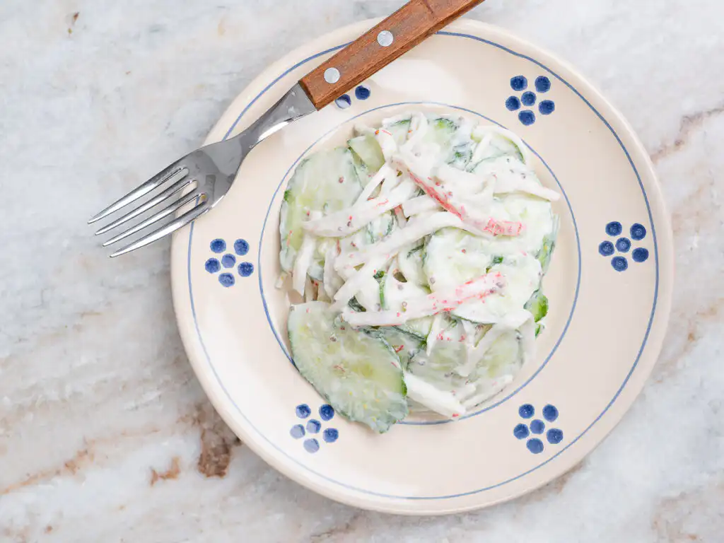 close up texture shot of creamy cucumber salad with greek yogurt dressing