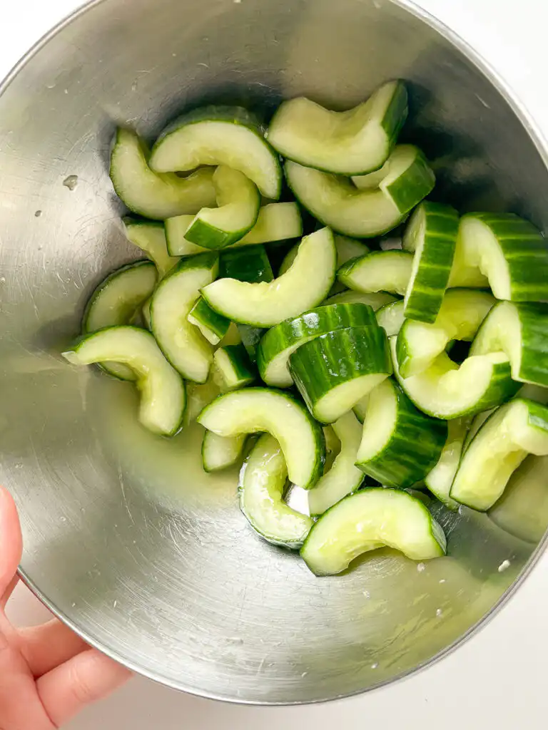 Liquid released from salted cucumber cubes being drained before seasoning