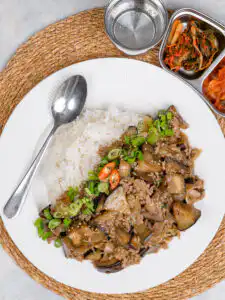 Korean eggplant rice bowl with ground meat and oyster sauce served in a white bowl