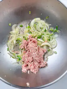 Ground meat cooking in a pan until no pink remains