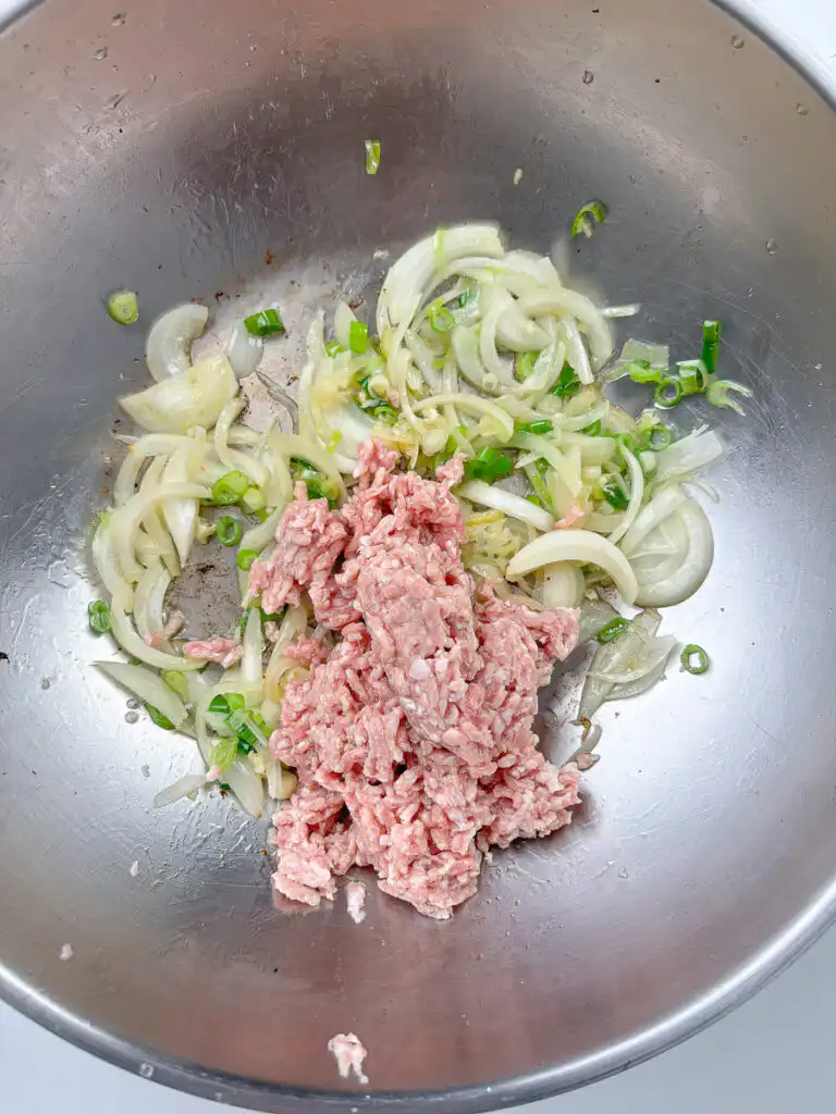 Ground meat cooking in a pan until no pink remains