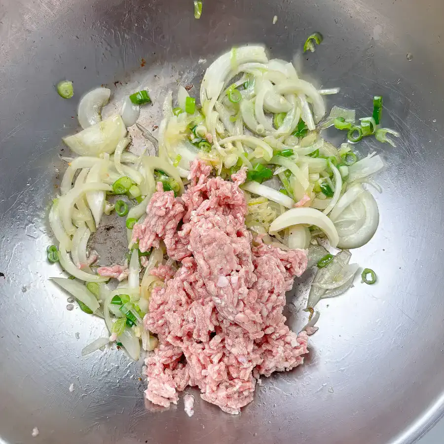 Ground meat cooking in a pan until no pink remains