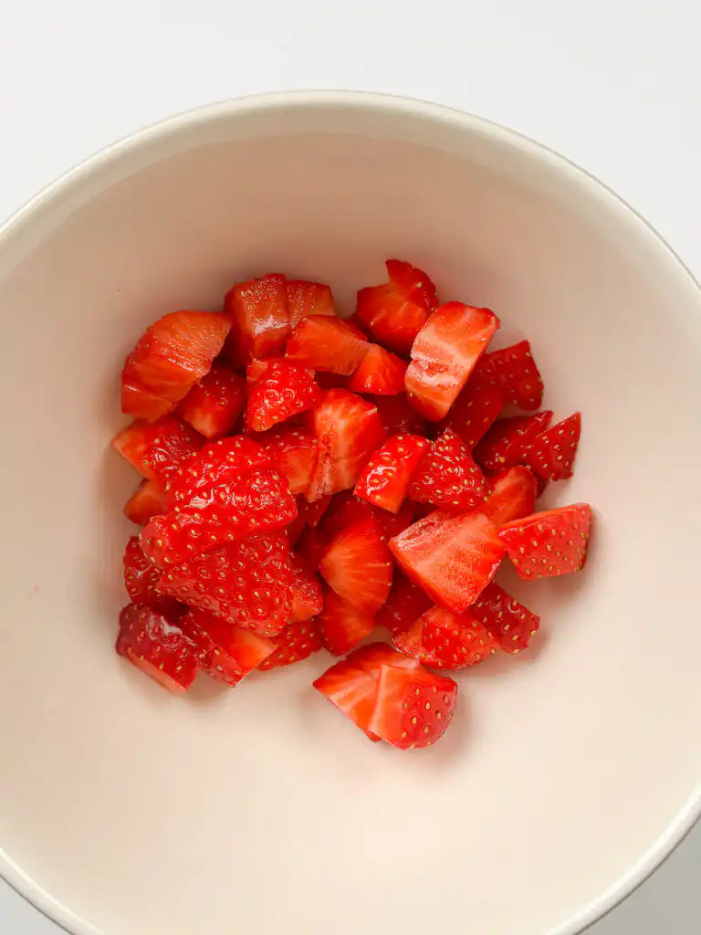 strawberry cubes macerating with sugar in a bowl for strawberry matcha ice cream