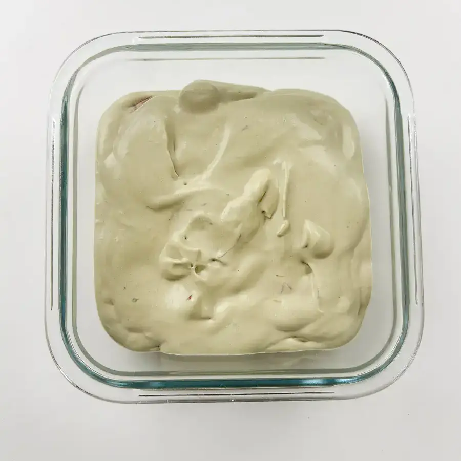 Viral Strawberry Matcha Ice Cream Sandwich matcha strawberry cream being spread over waffle cookie layer - easy matcha ice cream recipe