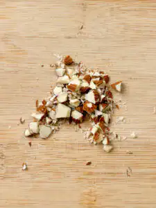 Natural Wegovy Healthy Egg Breakfast: GLP-1 Food almonds on wooden cutting board being roughly chopped knife large irregular pieces