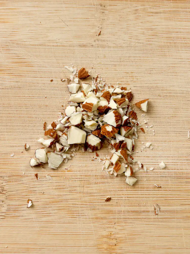 Natural Wegovy Healthy Egg Breakfast: GLP-1 Food almonds on wooden cutting board being roughly chopped knife large irregular pieces