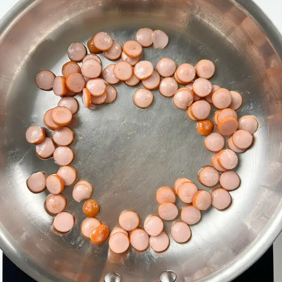Sausage and Rice Recipe: 5-Min Korean Sausage Butter Rice Sausage rounds sizzling in olive oil for easy sausage rice recipe, starting to turn golden