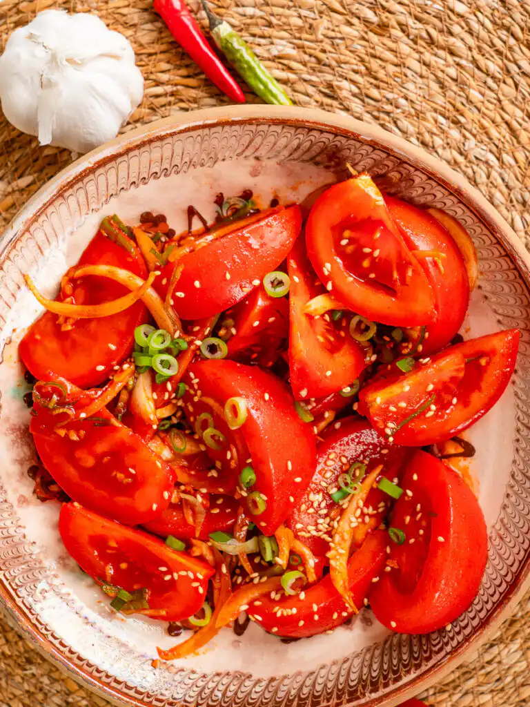 Tomato Kimchi Recipe: No Fermentation, Ready in 10 Minutes Korean tomato kimchi with gochugaru and green onion close-up