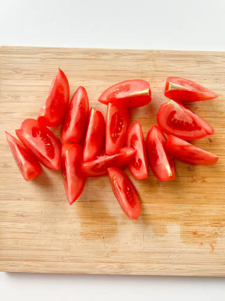 cutting tomatoes into wedges for quick kimchi recipe