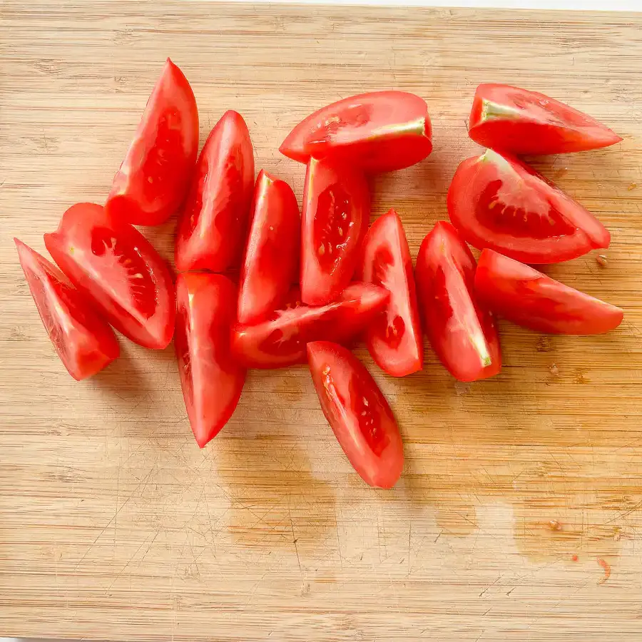Tomato Kimchi Recipe: No Fermentation, Ready in 10 Minutes cutting tomatoes into wedges for quick kimchi recipe