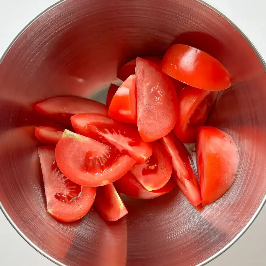 Tomato Kimchi Recipe: No Fermentation, Ready in 10 Minutes sliced tomatoes in a mixing bowl for the quick kimchi recipe