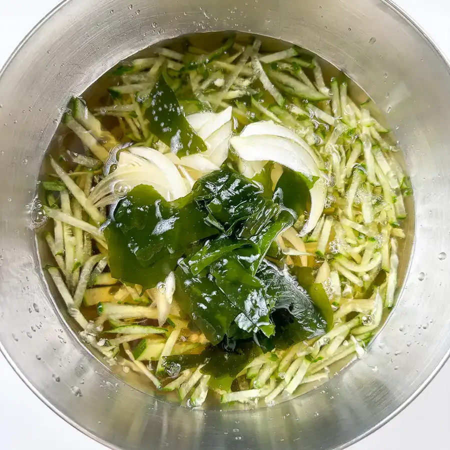 Korean Cucumber Soup (Oi Naengguk) - Best Cold Summer Soup Adding julienned cucumber and onion to the oi naengguk broth