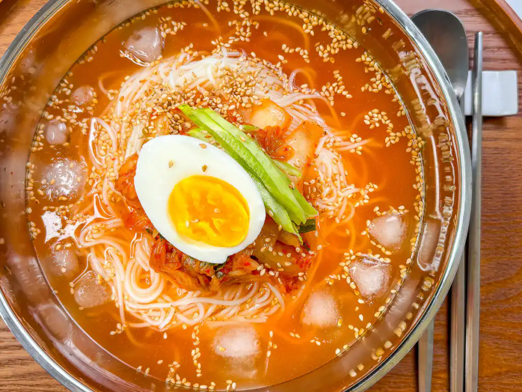 Grandma's Kimchi Korean Cold Noodles - Kimchi Mari Guksu Korean cold noodles topped with seasoned kimchi and julienned cucumber