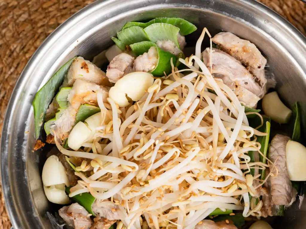 Spring Onion Bossam (Suyuk) – Juicy Waterless Pork Belly steaming spring onion bossam recipe in pot with lots of bean sprouts