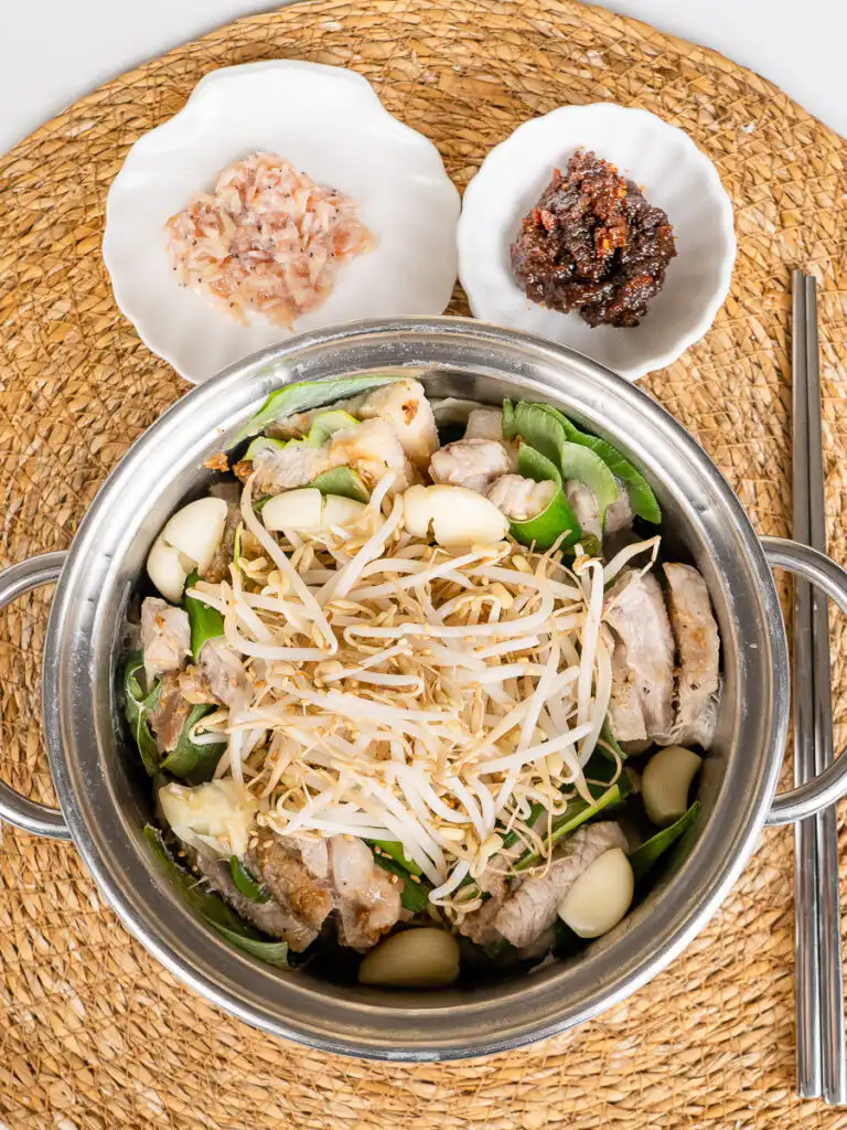 Spring Onion Bossam (Suyuk) – Juicy Waterless Pork Belly A close look at this spring onion bossam recipe, healthy vegetables and juicy protein together, chopsticks resting nearby.