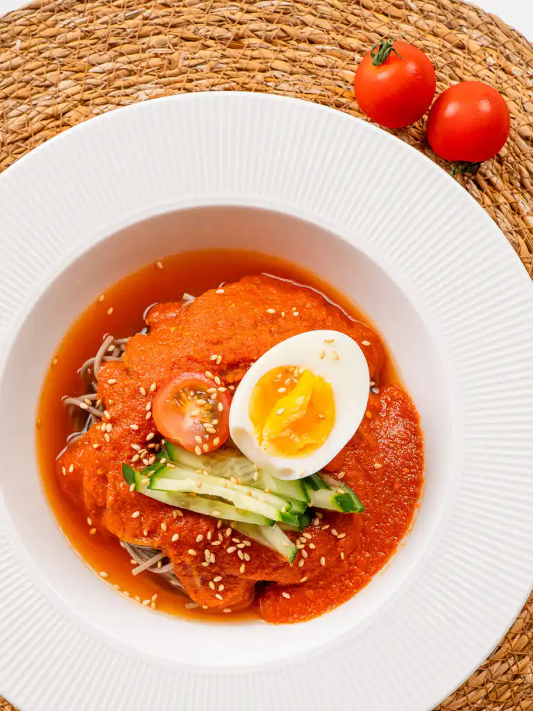 Tomato Gochujang Bibim Guksu - Summer Spicy Cold Noodles gochujang tomato noodles with sesame seeds and sesame oil drizzle