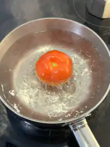 Tomato Gochujang Bibim Guksu - Summer Spicy Cold Noodles blanching tomato in boiling water for gochujang bibim guksu sauce