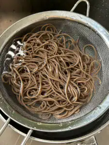 Tomato Gochujang Bibim Guksu - Summer Spicy Cold Noodles rinsing cooked buckwheat noodles under cold running water