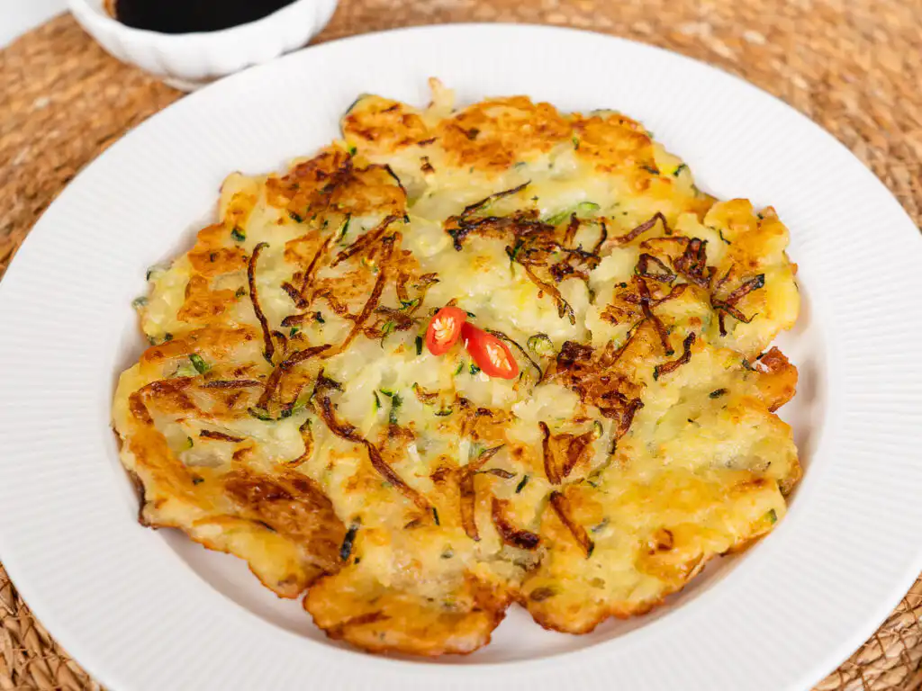 Crispy korean zucchini pancake on a white plate