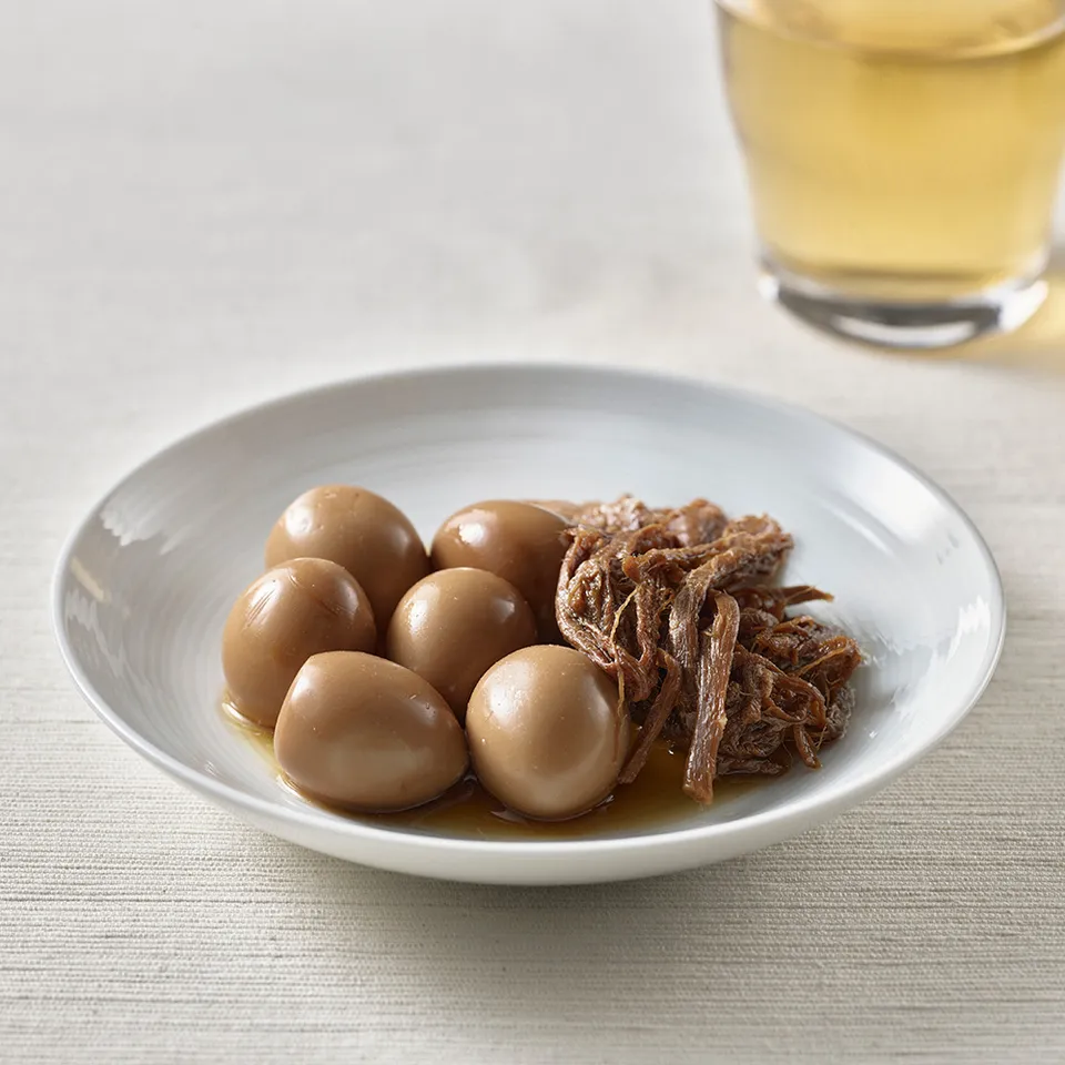 Close-up of muji banchan jangjorim showing glossy soy-braised beef and whole quail eggs