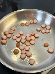 Buldak Fried Rice: Stress Blowing Buldak Sauce Rice in 10min Sausage slices frying golden brown in a pan to make buldak fried rice